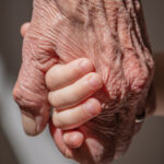 Close-up picture of an old and young hand.