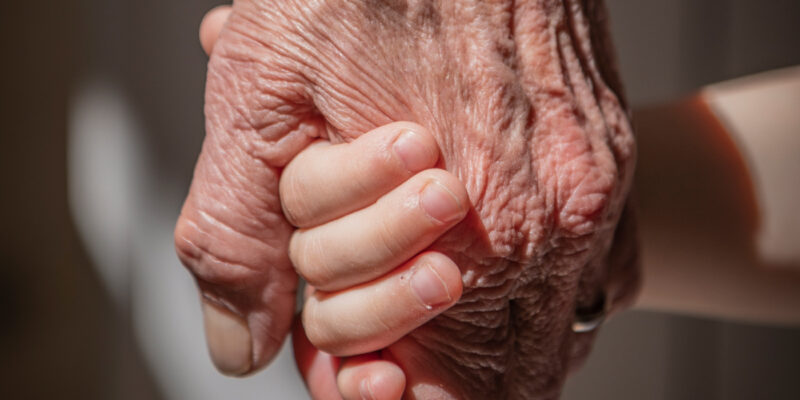 Close-up picture of an old and young hand.